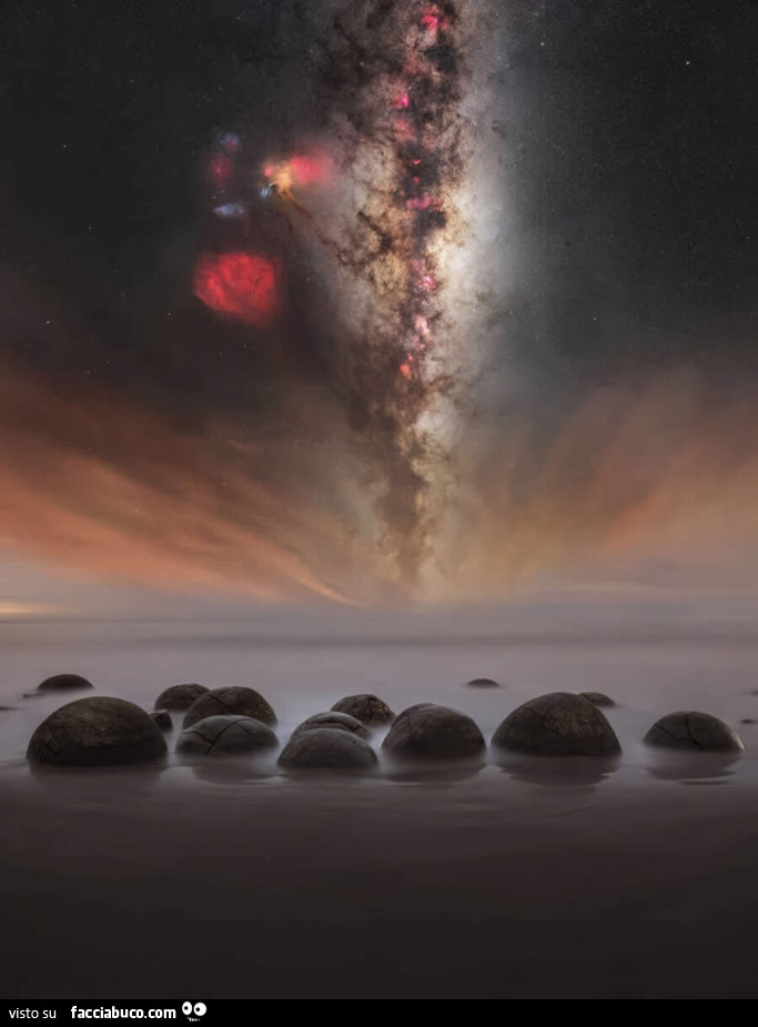 La Via Lattea si staglia sopra il mare, come una cascata, nel cielo notturno dell'emisfero Australe, a Moeraki Boulders, Nuova Zelanda
