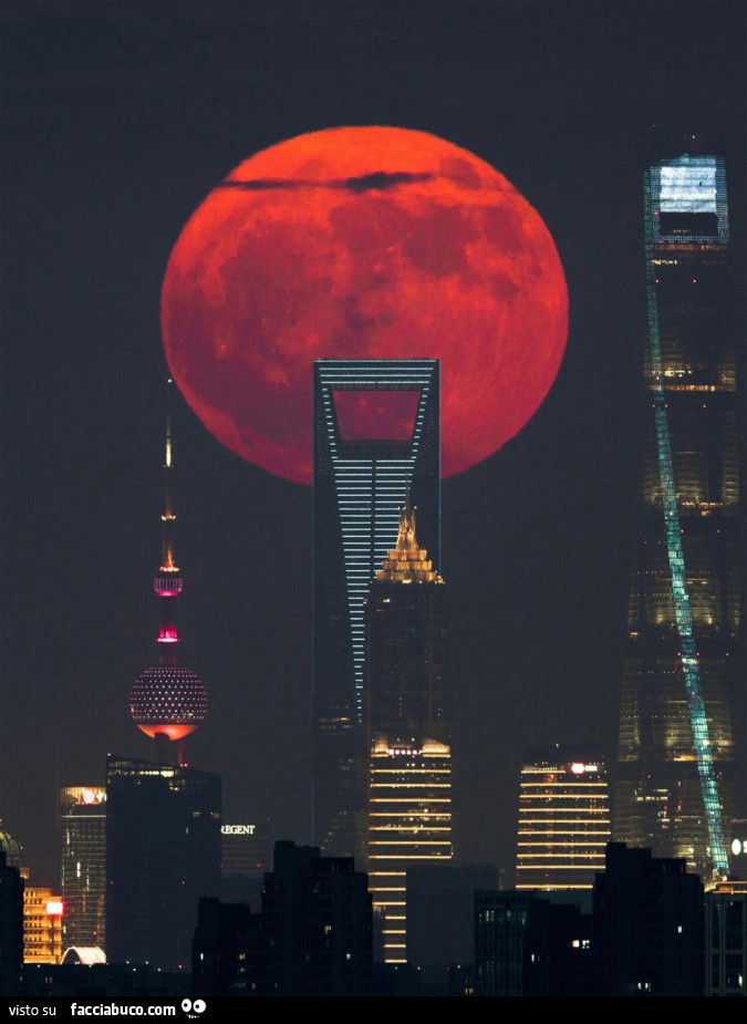 Luna Piena Rossa che sorge accanto ai grattacieli di Lujiazui, il cuore pulsante di Shanghai