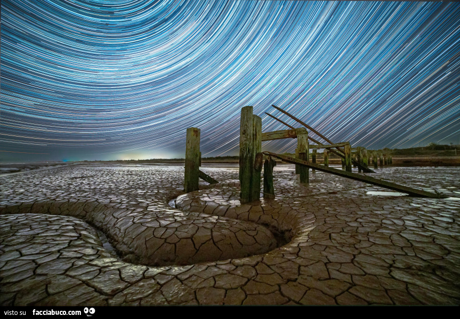 Canale curvo nella distesa fangosa di Snettisham Beach (Norfolk, Regno Unito) riflette il moto apparente delle stelle © © Paul Haworth